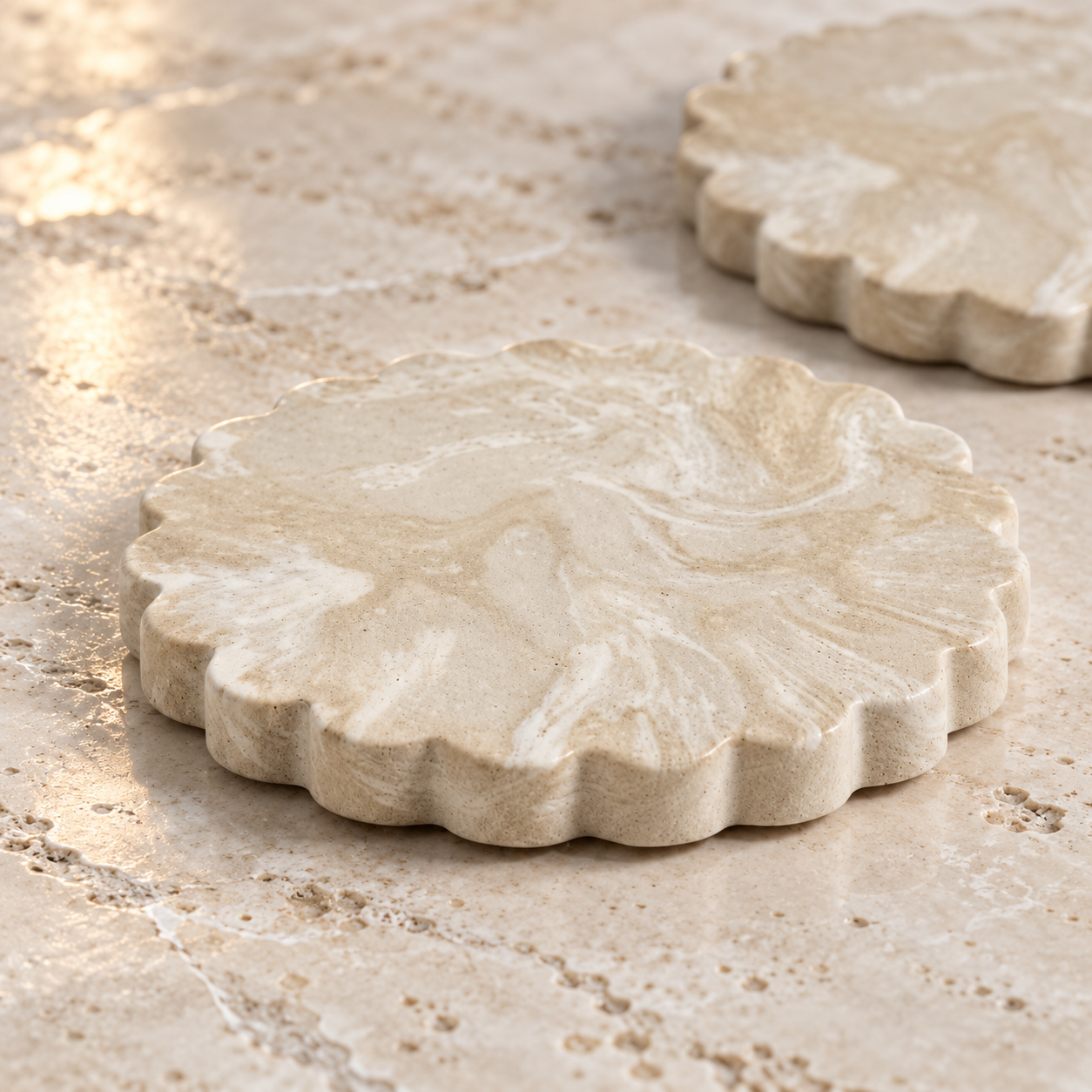Close detail of cream scalloped concrete coasters on travertine